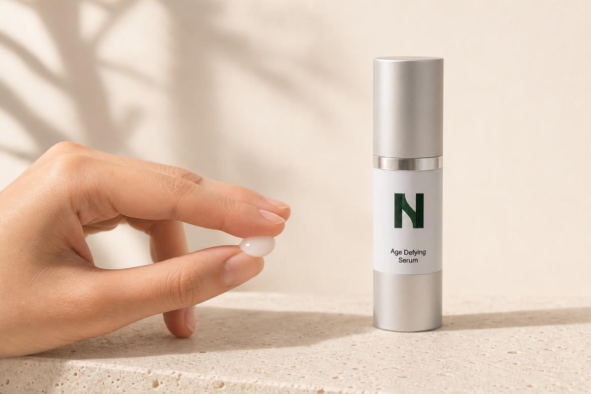 Bout des doigts tenant une goutte de Sérum anti-âge
